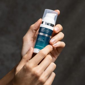 Bielenda's normalising nighttime cream for men, part of their men's skincare range and formulated specifcally for oily and combination skins. Photo shows the bottle held in the hands of a male customer, about to be used.